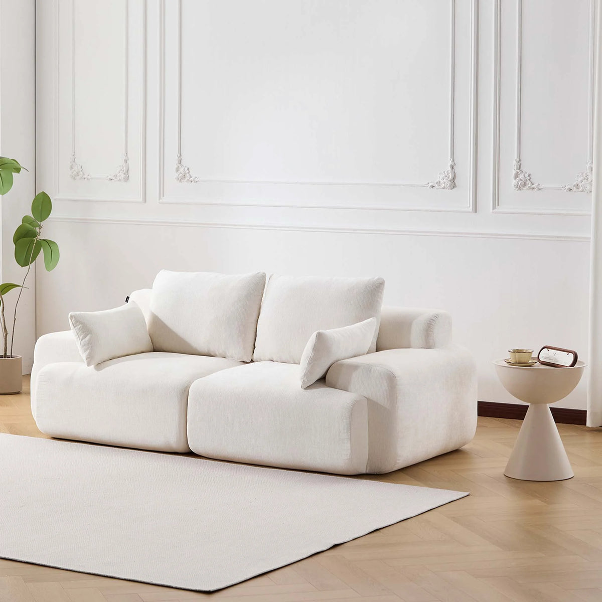 Komprimiertes 2-Sitzer-Sofa in Weiß, gepolstert, mit Zierkissen und breiter Sitzfläche