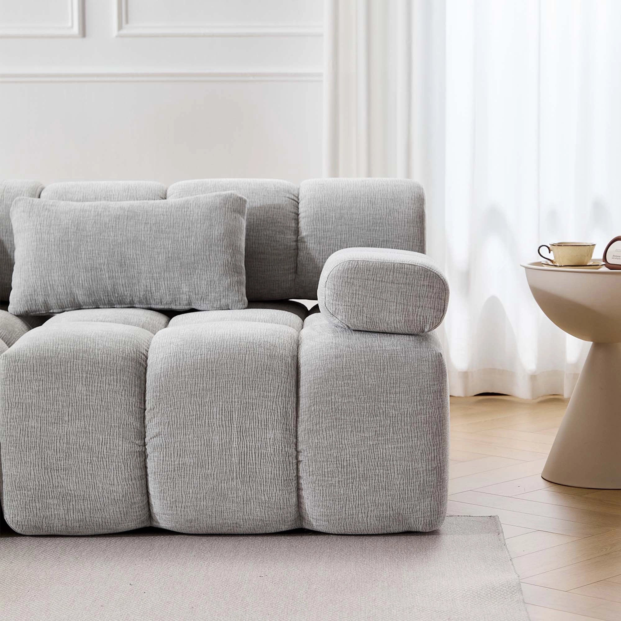 Komprimiertes Sofa (4-Sitzer) mit hellgrauen, breiten Armlehnen und Eckmodul