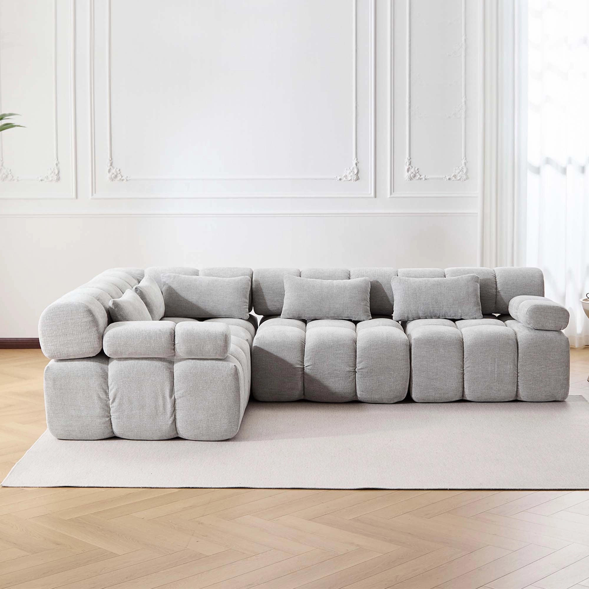 4-Sitzer Sofa mit hellgrauen Kompressions-Polsterblöcken und großen Armteilen
