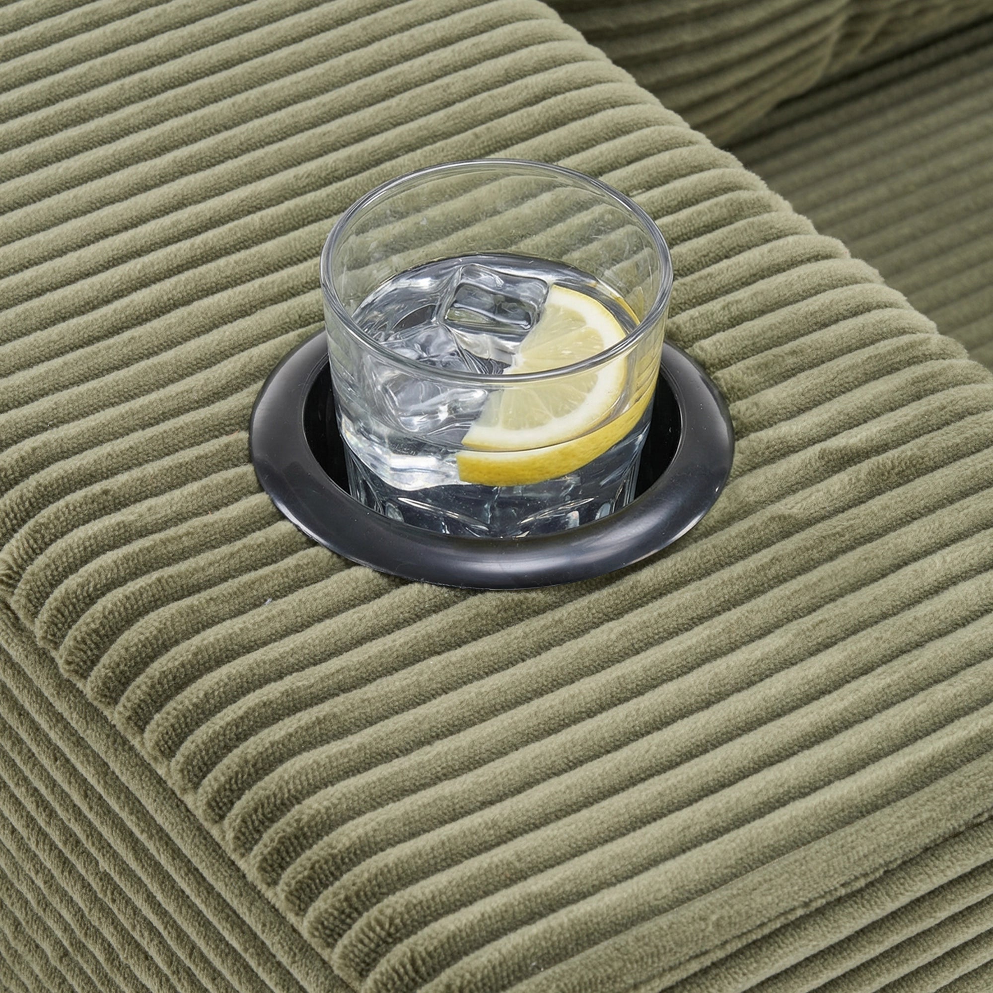 Cordsofa-Detail: geripptes Material in olivgrün, mit Glas und Zitrone auf der Sitzfläche
